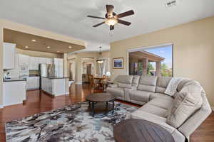 Living room featuring dark wood finished floors, ceiling fan, and recessed lighting