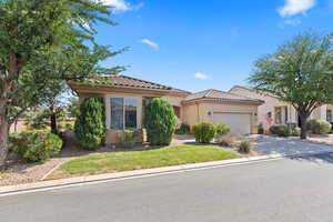 Mediterranean / spanish-style home with stucco siding, a garage, driveway, and a tiled roof