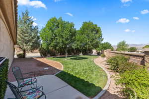 View of grassy yard with a patio area and a mountain view