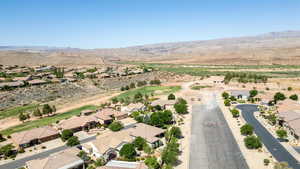 Aerial view of residential area featuring a mountain backdrop and a golf club