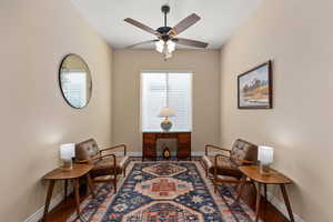 Sitting room with wood finished floors and a ceiling fan