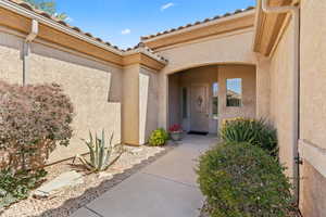 Doorway to property with stucco siding and a tile roof