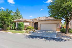 Mediterranean / spanish house featuring an attached garage, concrete driveway, stucco siding, and a tile roof