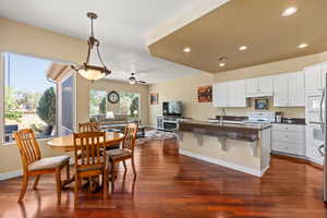 Kitchen with dark countertops, open floor plan, a textured ceiling, dark wood-style floors, and white cabinetry
