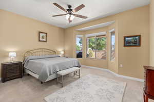 Bedroom featuring light carpet and a ceiling fan