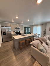 Kitchen featuring gray cabinets, appliances with stainless steel finishes, light countertops,  and open floor plan