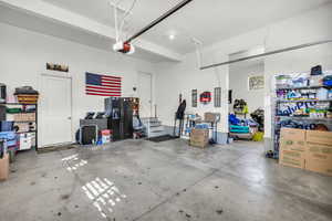 Garage featuring black fridge with ice dispenser and a garage door opener