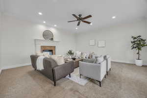 Living area featuring light carpet, recessed lighting, ceiling fan, crown molding, and a tile fireplace