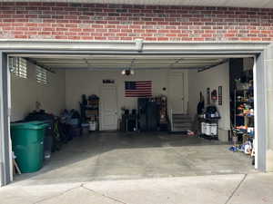 Garage with concrete driveway and black fridge