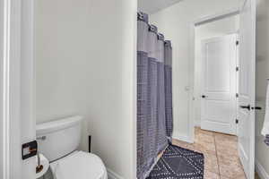 Bathroom with toilet and curtained shower