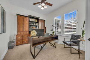 Office with light colored carpet and a ceiling fan