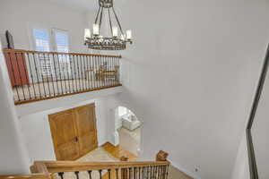 Stairway featuring a chandelier and baseboards