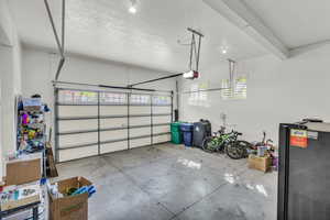 Garage with freestanding refrigerator and a garage door opener