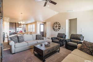 Living area featuring a ceiling fan, vaulted ceiling, a chandelier, and recessed lighting