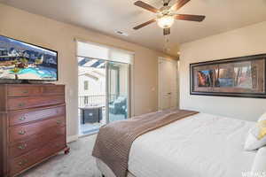 Bedroom featuring access to exterior, light carpet, and a ceiling fan