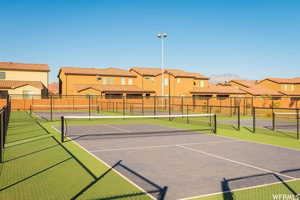 View of tennis court with a residential view