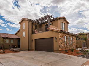 Mediterranean / spanish house with an attached garage, concrete driveway, stucco siding, a balcony, and a tile roof