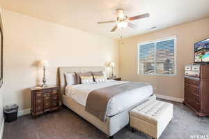 Carpeted bedroom featuring baseboards and ceiling fan
