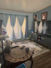 Living room with crown molding and wood finished floors