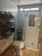 Bathroom with a shower stall, vanity, and a textured ceiling