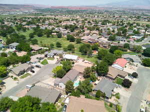 Aerial view of property and surrounding area featuring nearby suburban area and a mountain backdrop