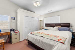 Bedroom featuring vaulted ceiling, light carpet, a closet, and ceiling fan