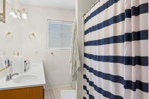 Full bathroom with double vanity and a shower with curtain