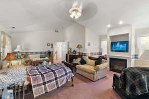 Bedroom with carpet flooring, vaulted ceiling, a glass covered fireplace, recessed lighting, and a ceiling fan