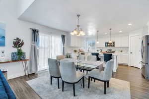 Dining area with a chandelier, wood finished floors, and recessed lighting