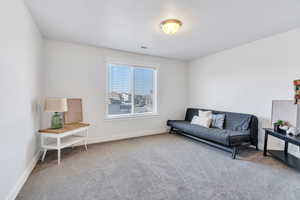 Carpeted living area featuring baseboards