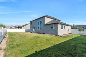 Rear view of house featuring stucco siding and a fenced backyard