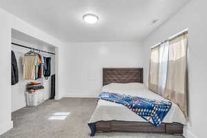 Carpeted bedroom with baseboards and a textured ceiling