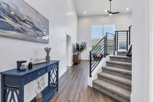 Entryway with stairs, wood finished floors, and recessed lighting