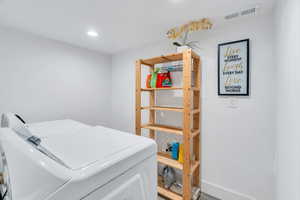 Washroom featuring independent washer and dryer and recessed lighting