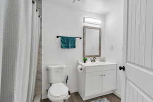 Bathroom featuring vanity, wood finished floors, a shower with curtain, and a textured ceiling