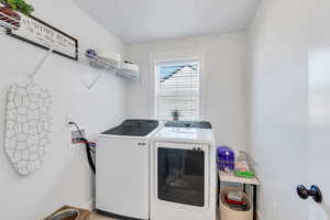 Laundry area with separate washer and dryer and baseboards
