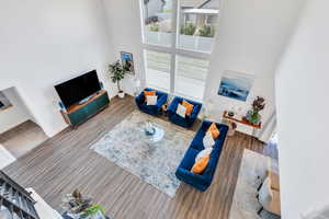 Living area featuring a towering ceiling and wood finished floors