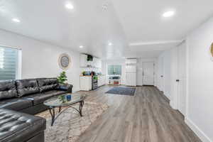 Living area with light wood-style floors and recessed lighting