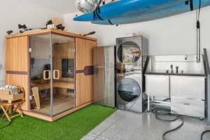Washroom featuring stacked washer / dryer and a sauna / steam room