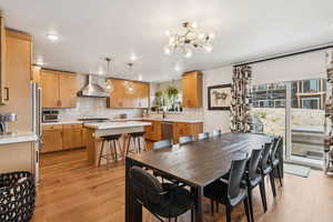 Dining area featuring light wood finished floors, a chandelier, and recessed lighting