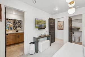 Bedroom featuring ensuite bathroom and baseboards
