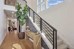 Staircase with wood finished floors and a high ceiling