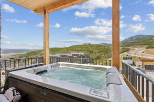 Wooden deck featuring a hot tub and a mountain view