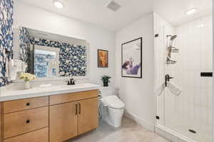 Full bath with a shower stall, vanity, and tile patterned floors