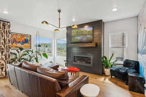 Living area with light wood-style floors, a large fireplace, and recessed lighting