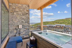 Balcony with a hot tub and a mountain view