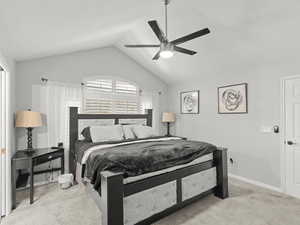 Carpeted bedroom with multiple windows, lofted ceiling, and ceiling fan