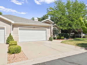 Ranch-style home with a garage, concrete driveway, stucco siding, and a shingled roof