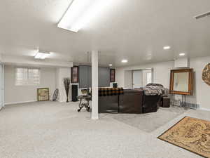 Carpeted living area with recessed lighting, a textured ceiling, and plenty of natural light