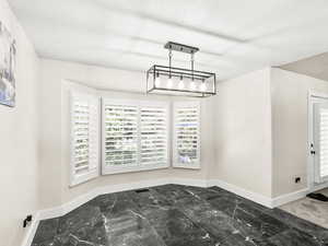 Dining area featuring marble finish floors and a textured ceiling